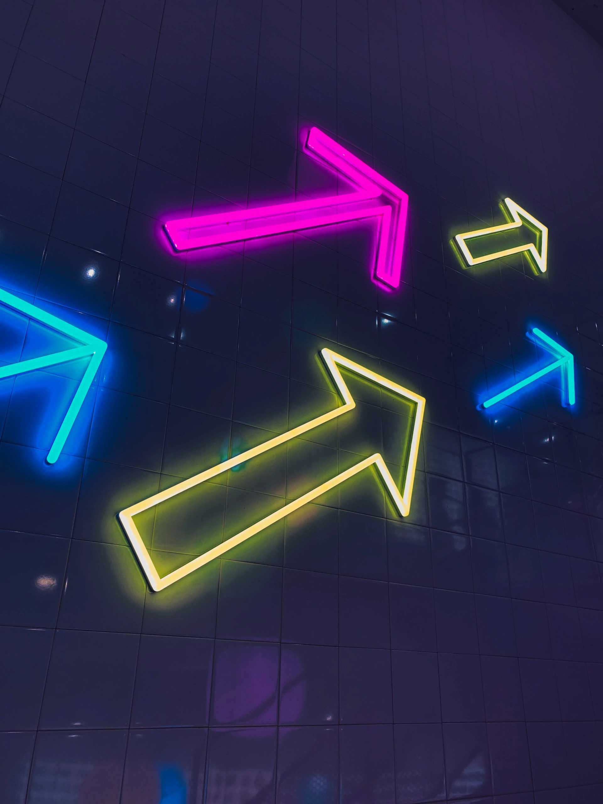 blue, pink, and yellow neon arrows on black background