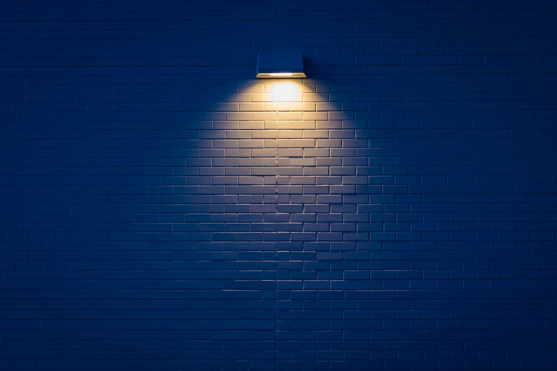 dark blue wall with a single yellow light