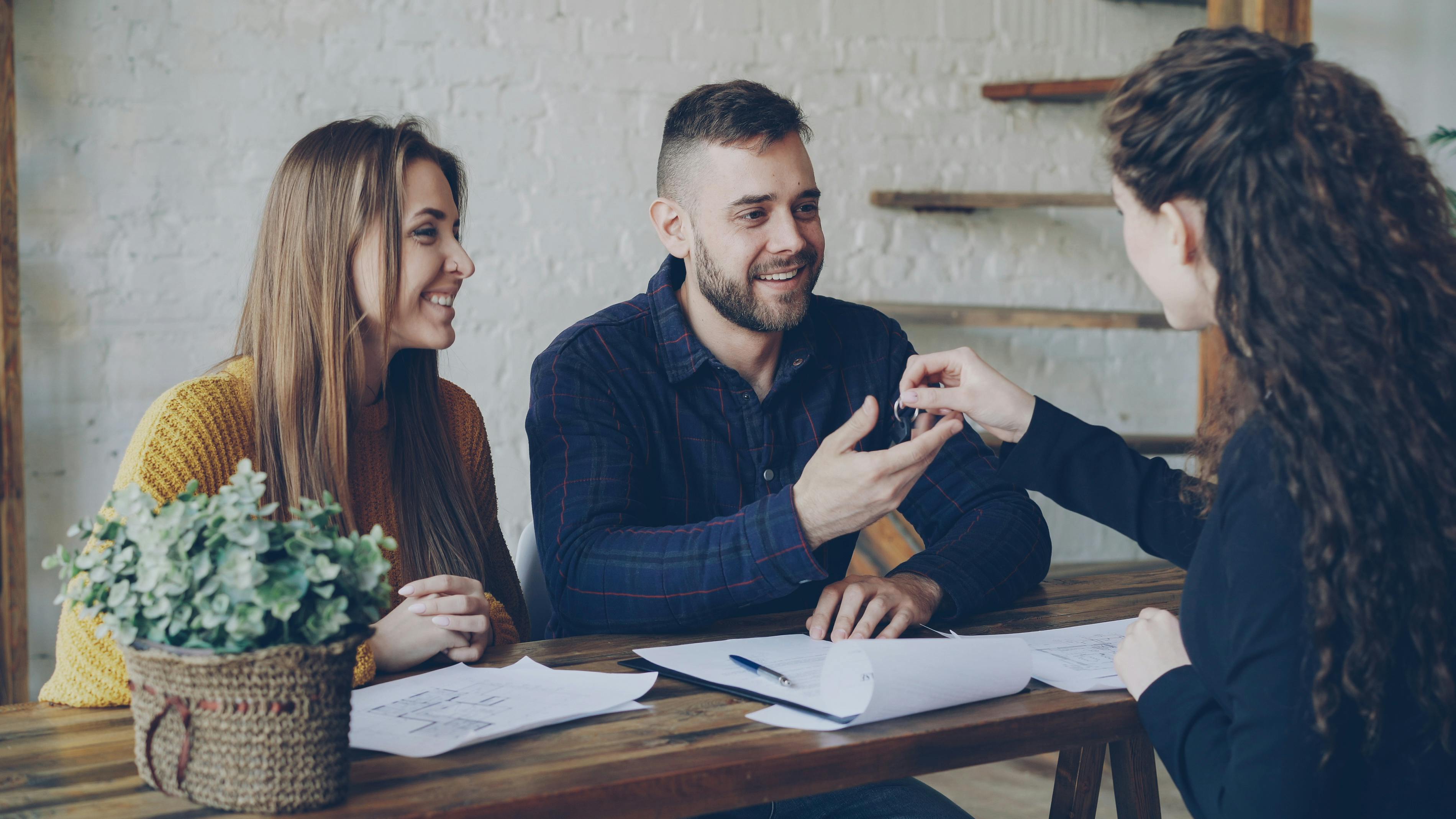 couple collecting keys from estate agent to first home