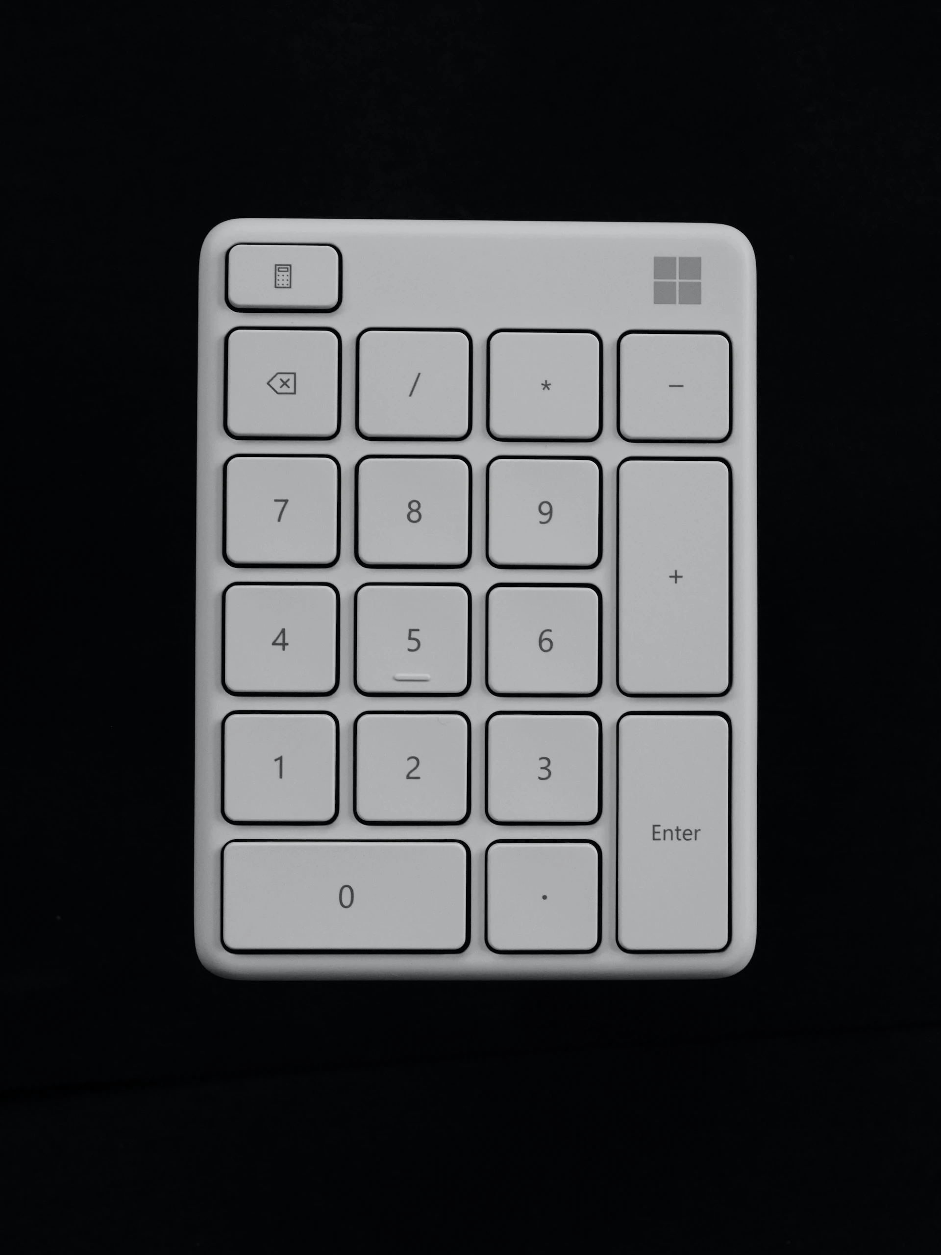 white calculator against a black background