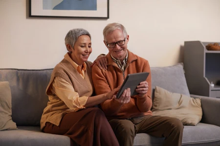 over 60s couple using a tablet on sofa