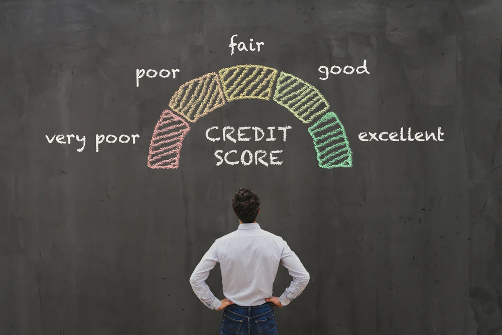 Man looking at credit score chart on blackboard