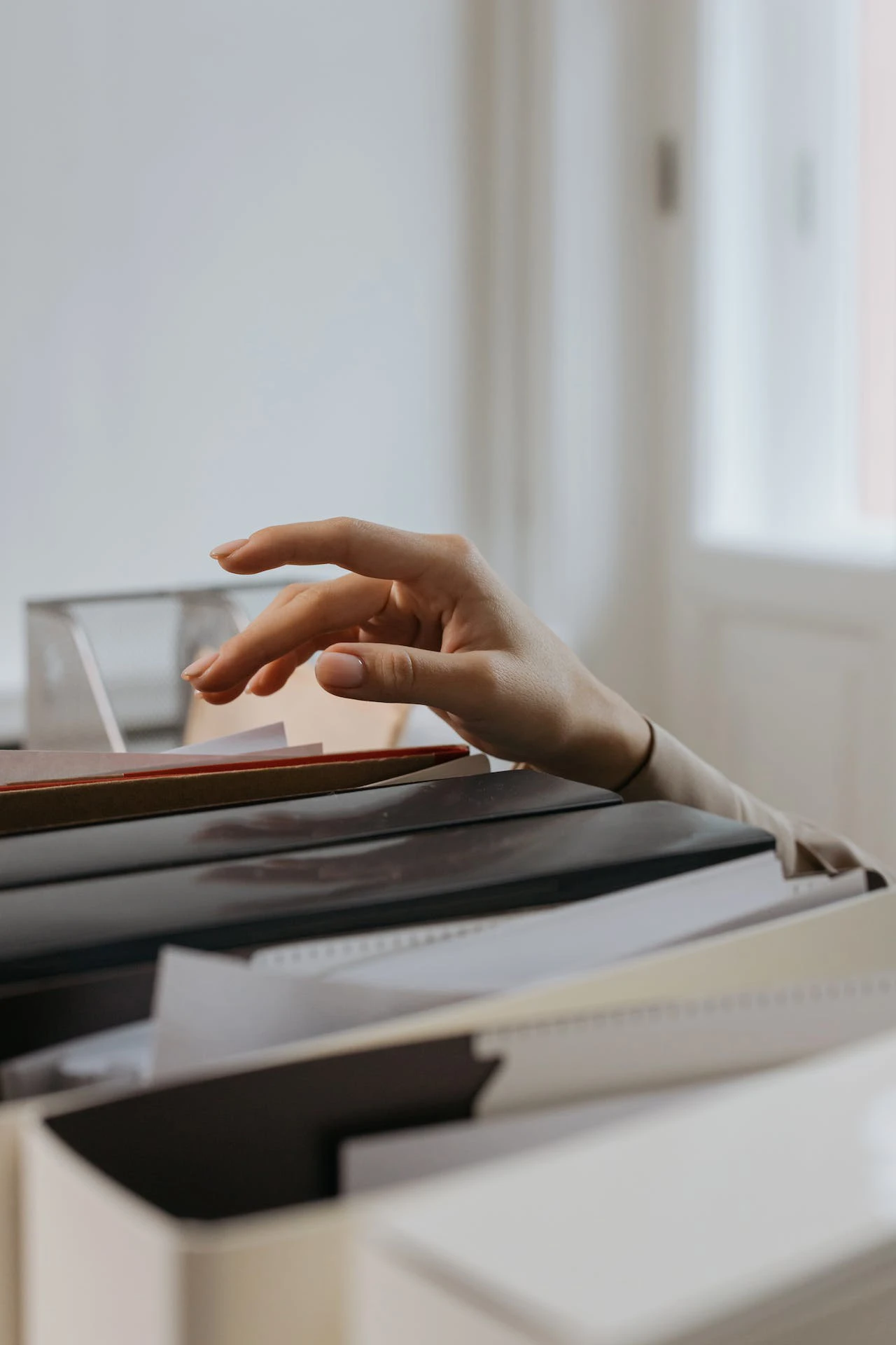 woman's hand hovering over files on a shelf