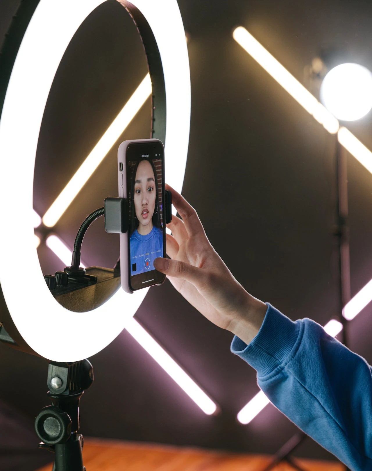 Woman using a phone to record herself, using a ring light for lighting
