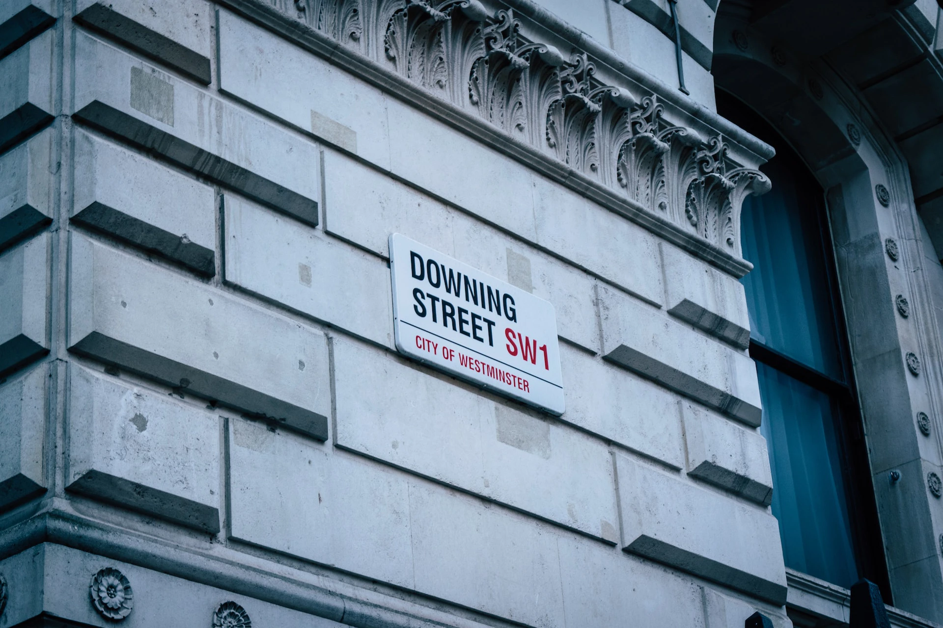 Street sign for Downing Street on stone wall