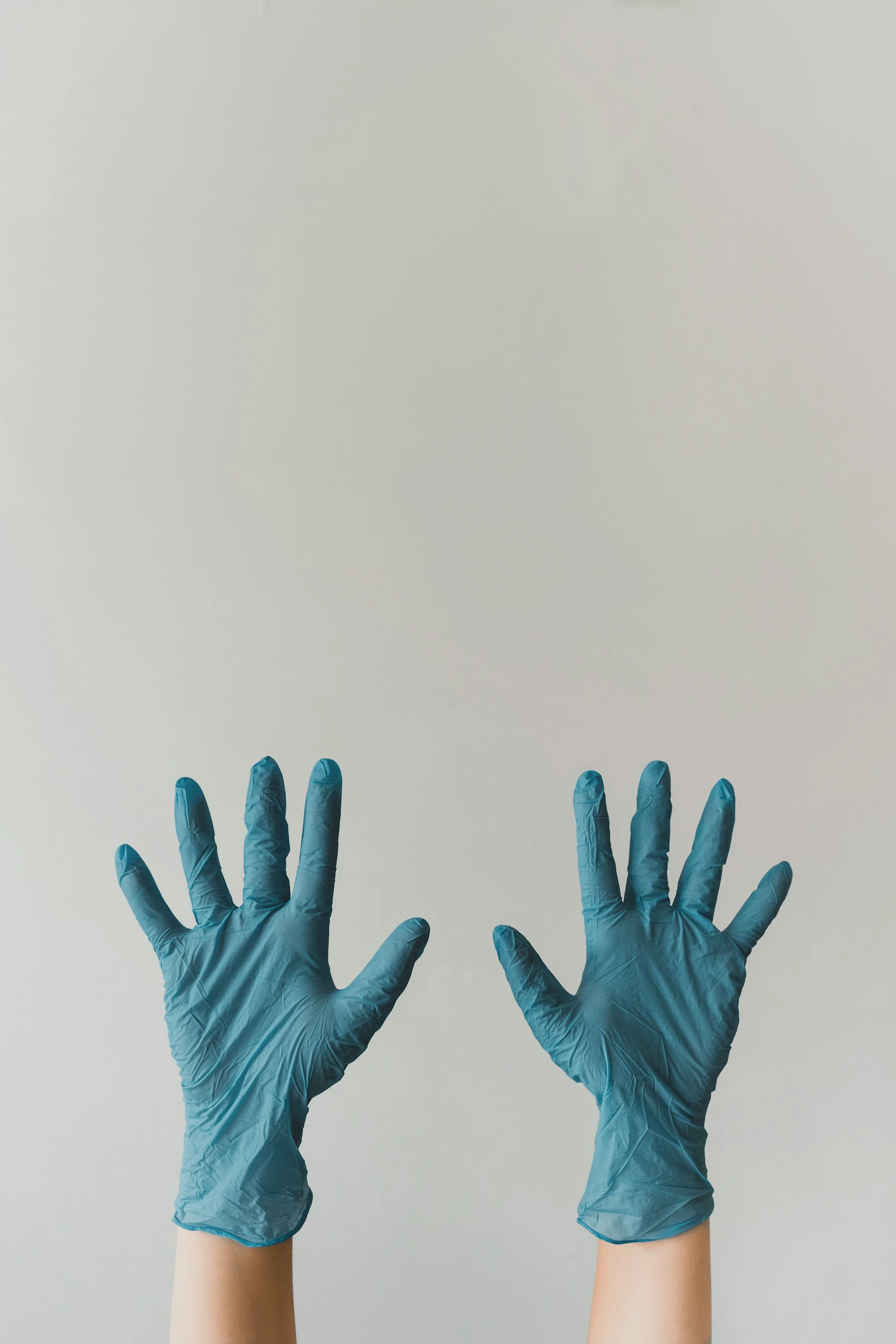 hands with blue gloves on them sticking up