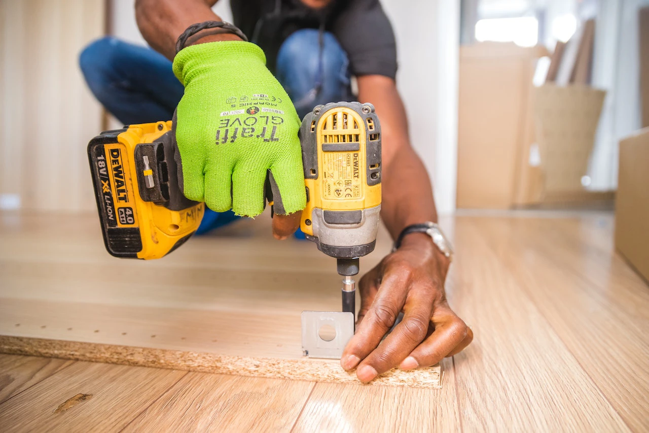 man drilling bracket into wood