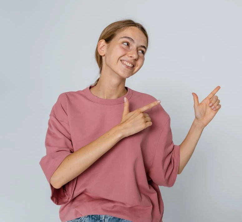 woman wearing dark pink jumper pointing to the right