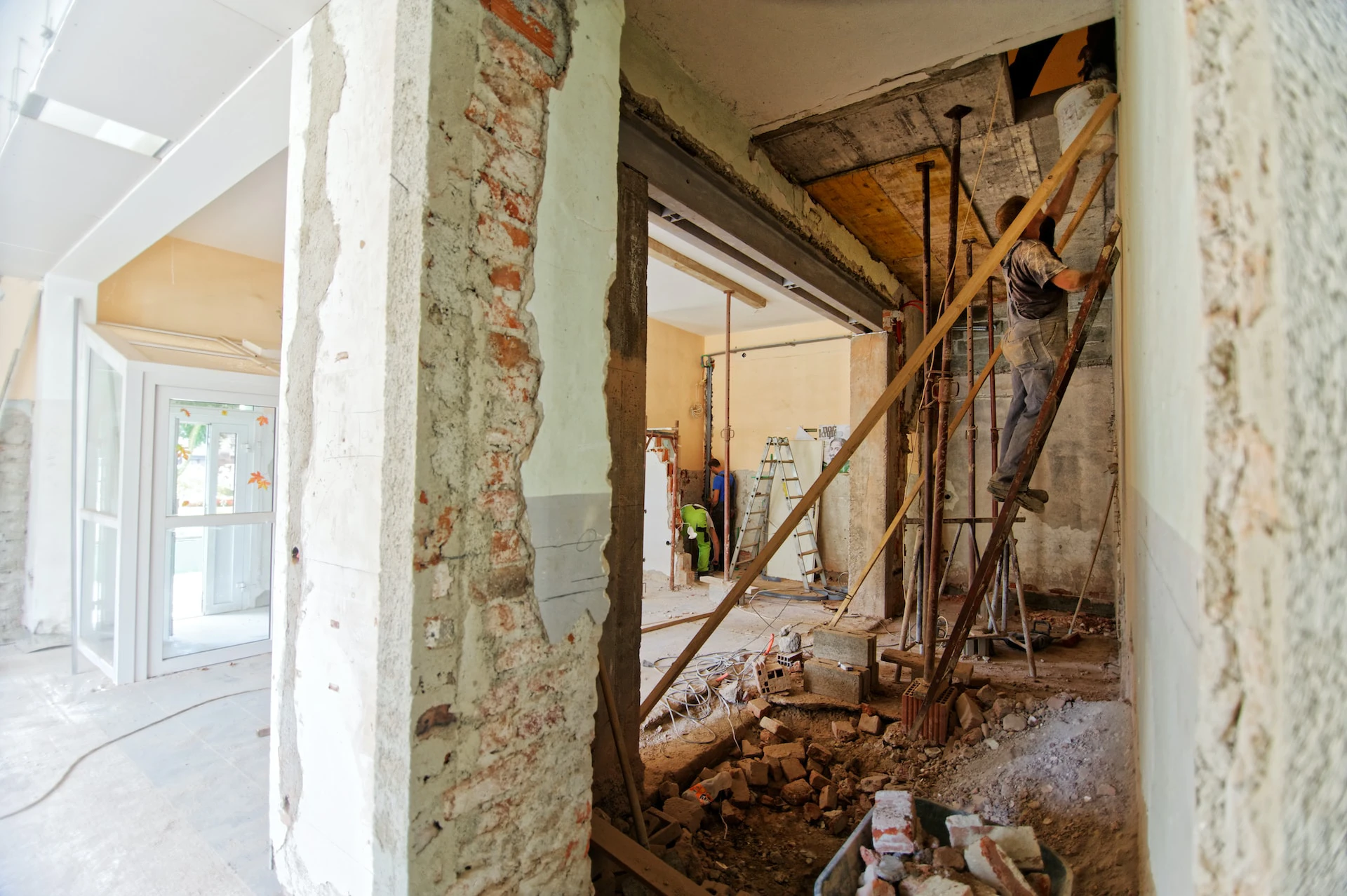interior of house with walls removed and builder working