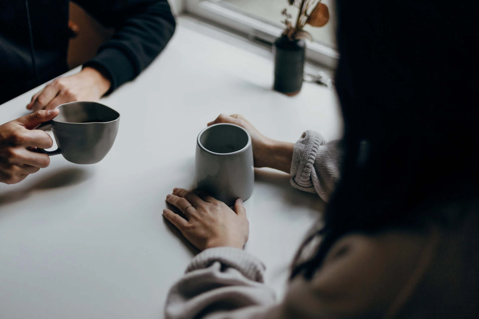 two people having a coffee, with the focus mostly on their hands