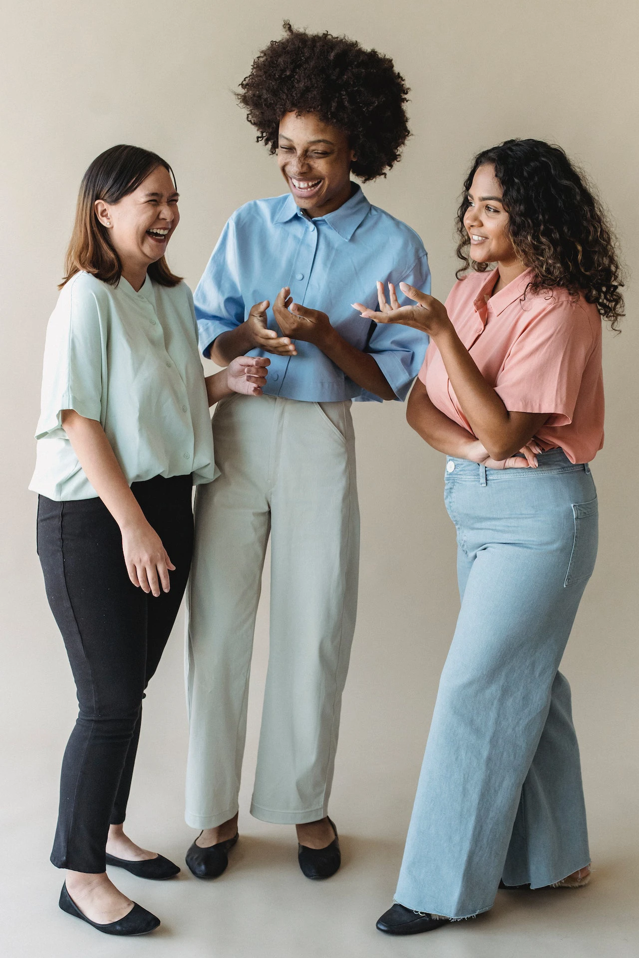 Group of three young woman talking to each other while standing up