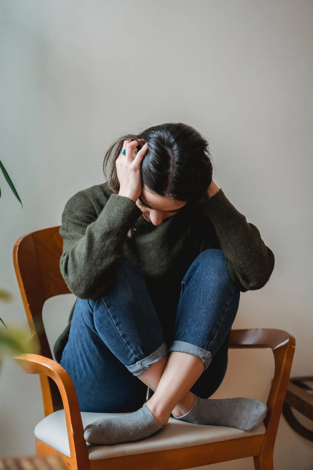 concerned woman sat cross-legged in a chair - Survey highlights financial anxieties - top money concerns for under 30s