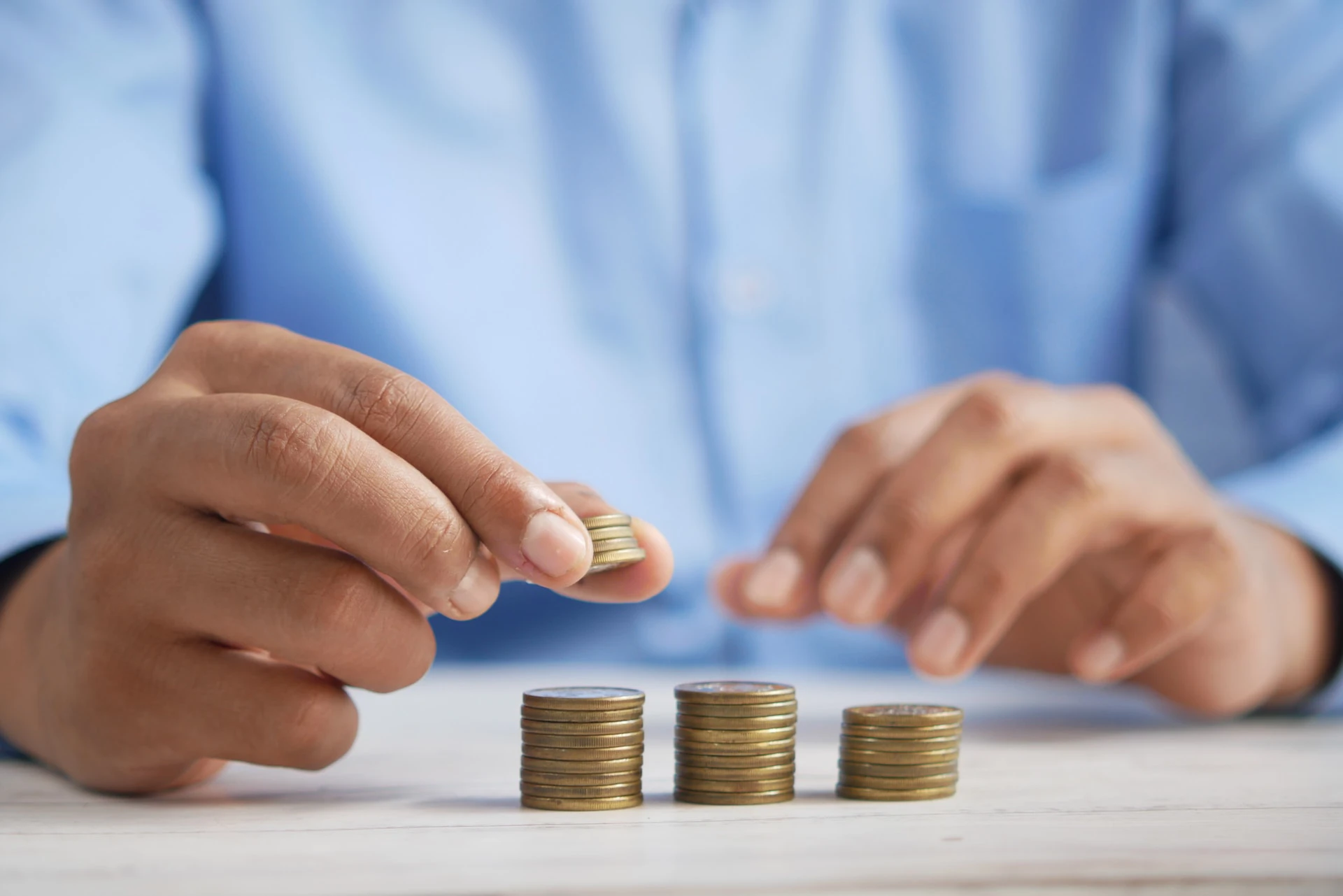 man in blue shirt counting coins