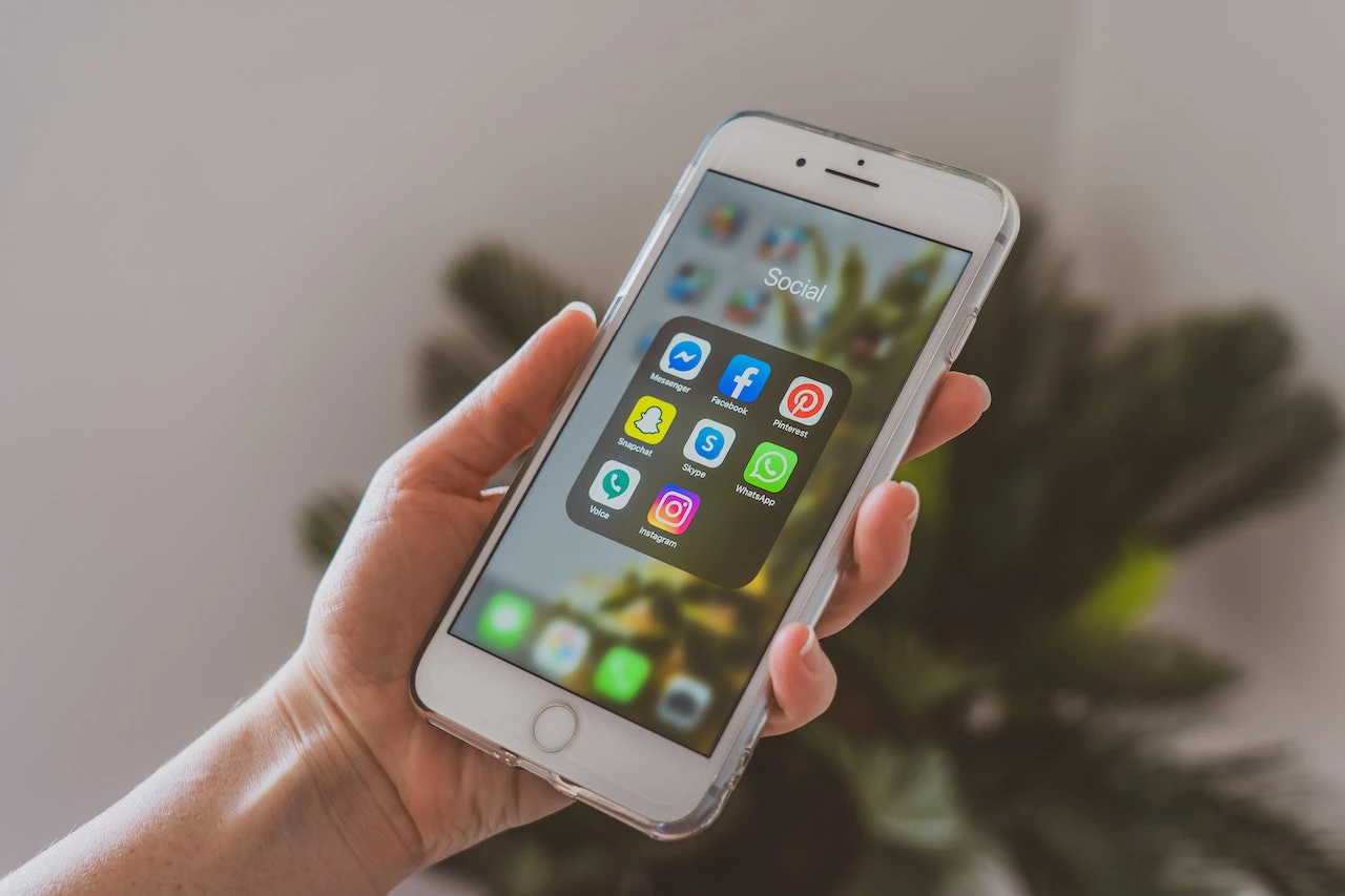 Someone holding a phone that displays a selection of social media apps