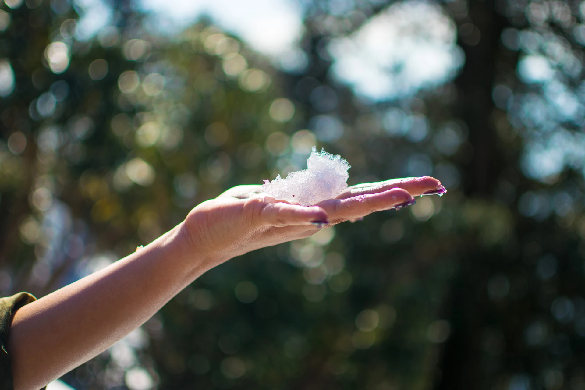 Woman holding a drop of snow to show the snowball method for debt reduction