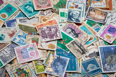 Pile of colourful stamps from all regions of the world laid flat