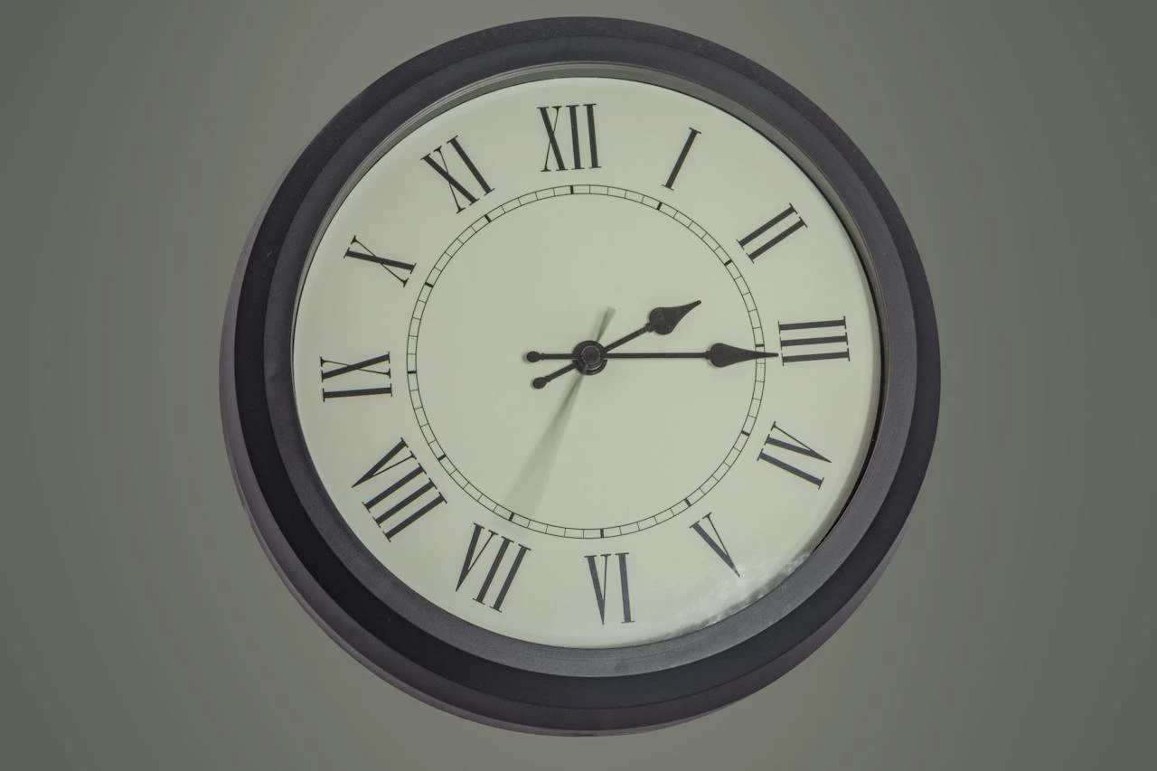 Round clock hanging on gray wall