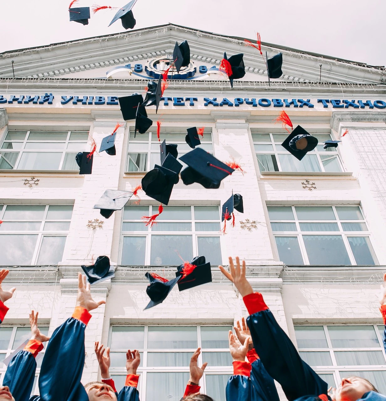 university students throwing graduation caps into the air