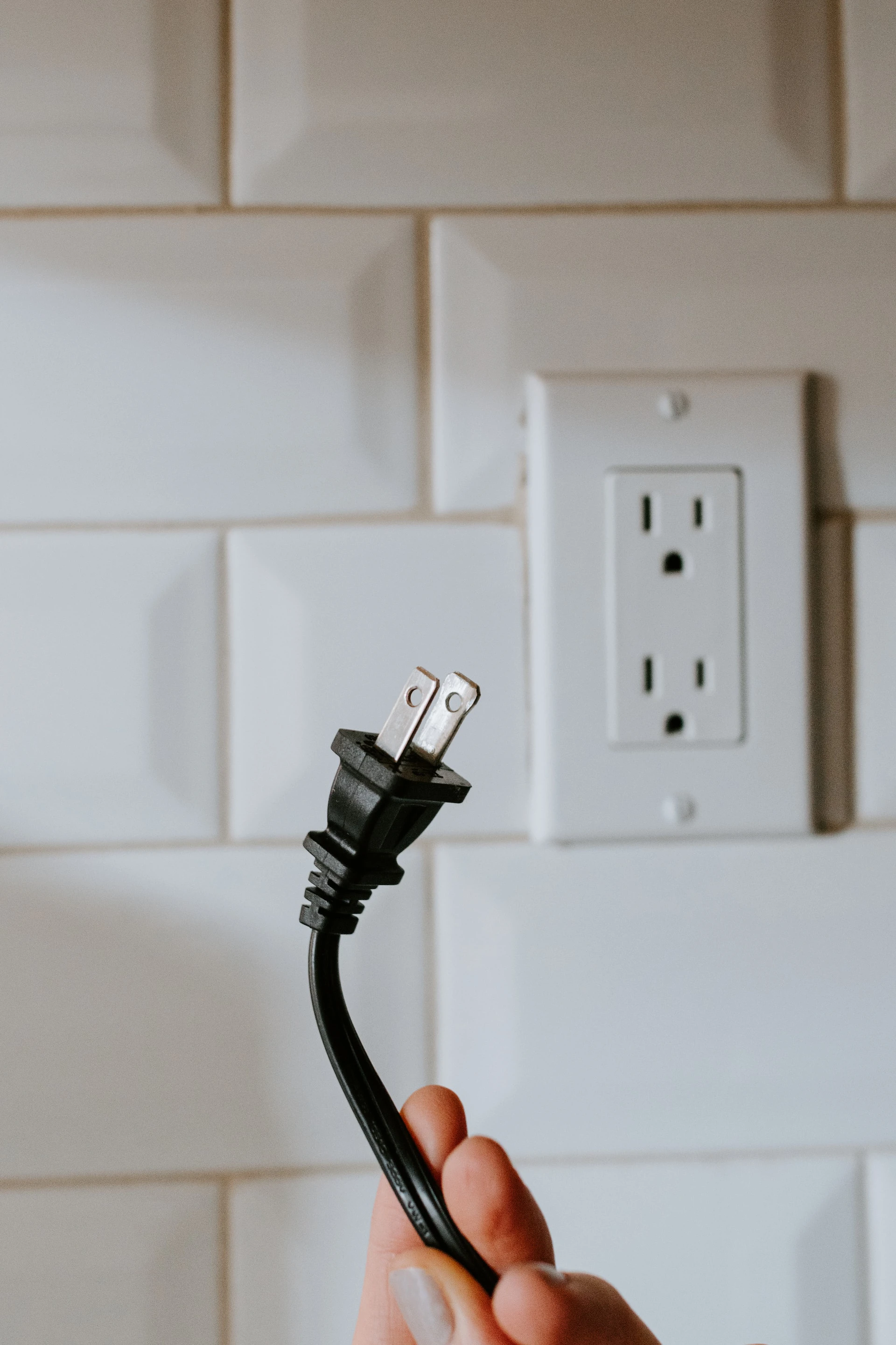 woman holding black unplugged cable