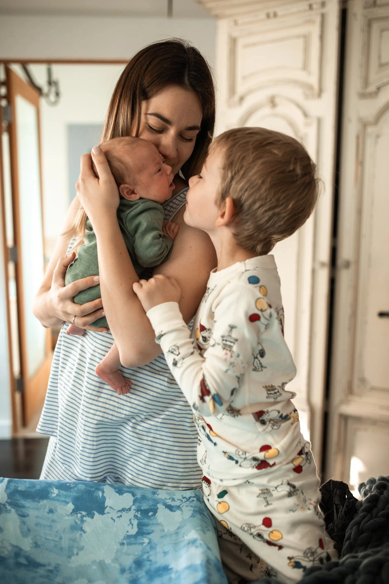 Boy Embracing his Mother Holding a Newborn Baby