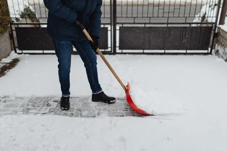 person shovelling snow from drive