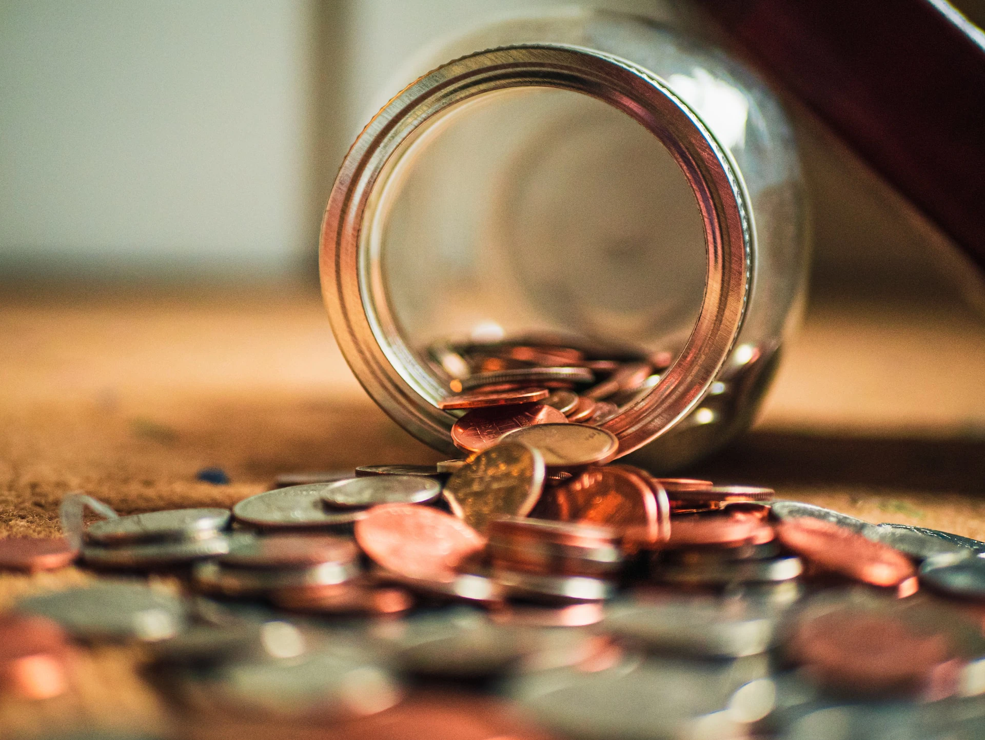 jar on its side with assorted coins spilling out