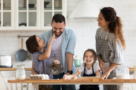 Overjoyed young family with little preschooler kids have fun cooking baking pastry or pie at home