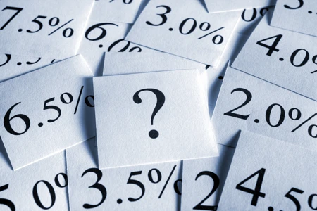 multiple percentages printed out on pieces of paper with a question mark at the centre