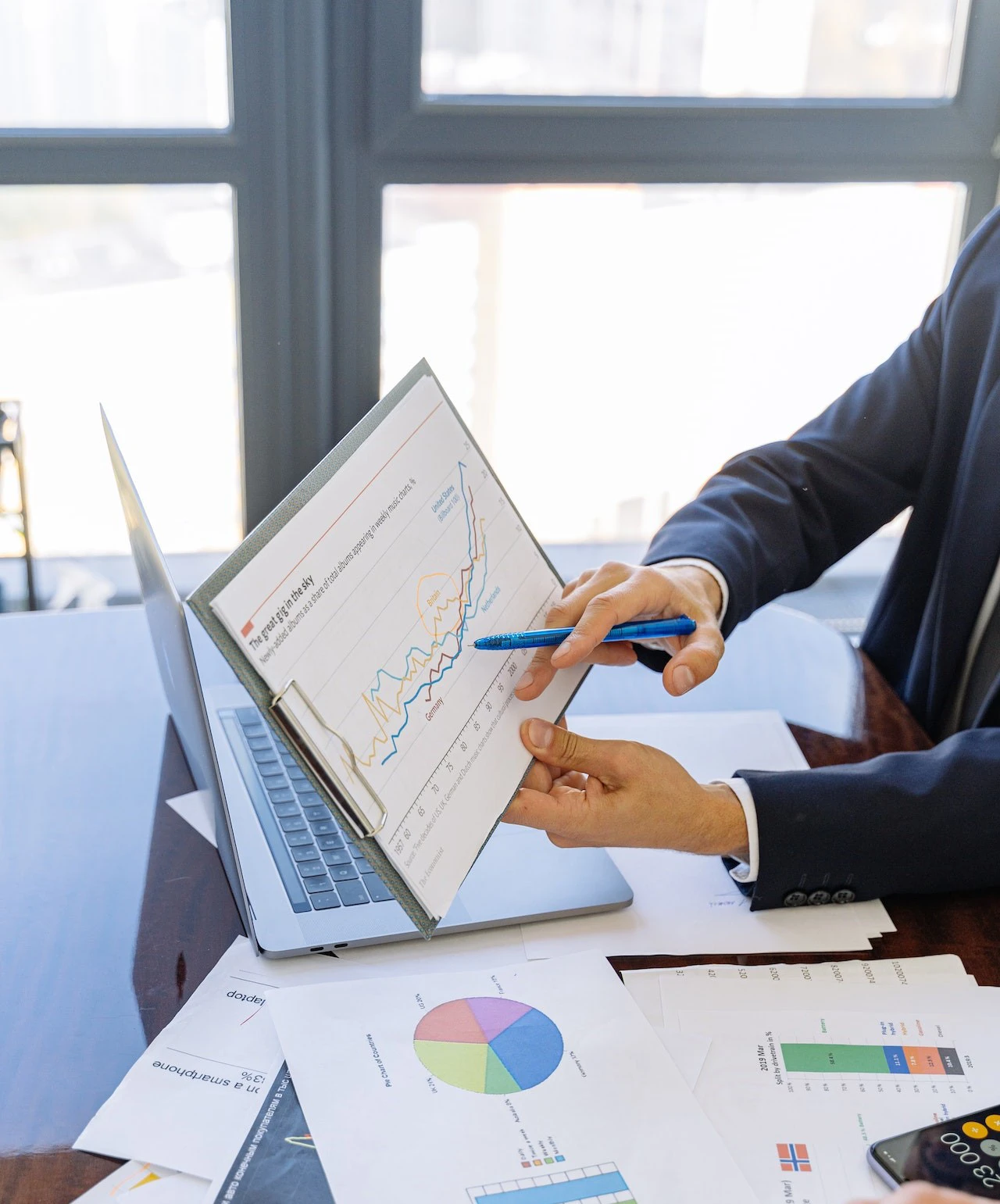 Person's hands pointing towards a graph